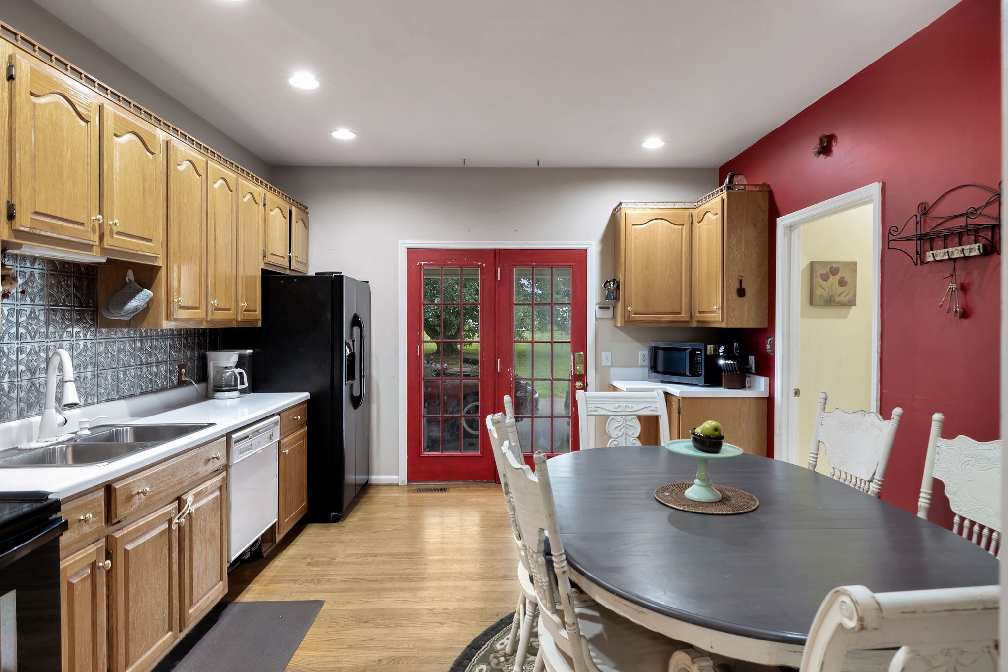876 Monument Road Summertown, TN 38483 - Photo 12 of 26 a kitchen with stainless steel appliances granite countertop a sink dishwasher a stove a refrigerator with a dining table and chairs