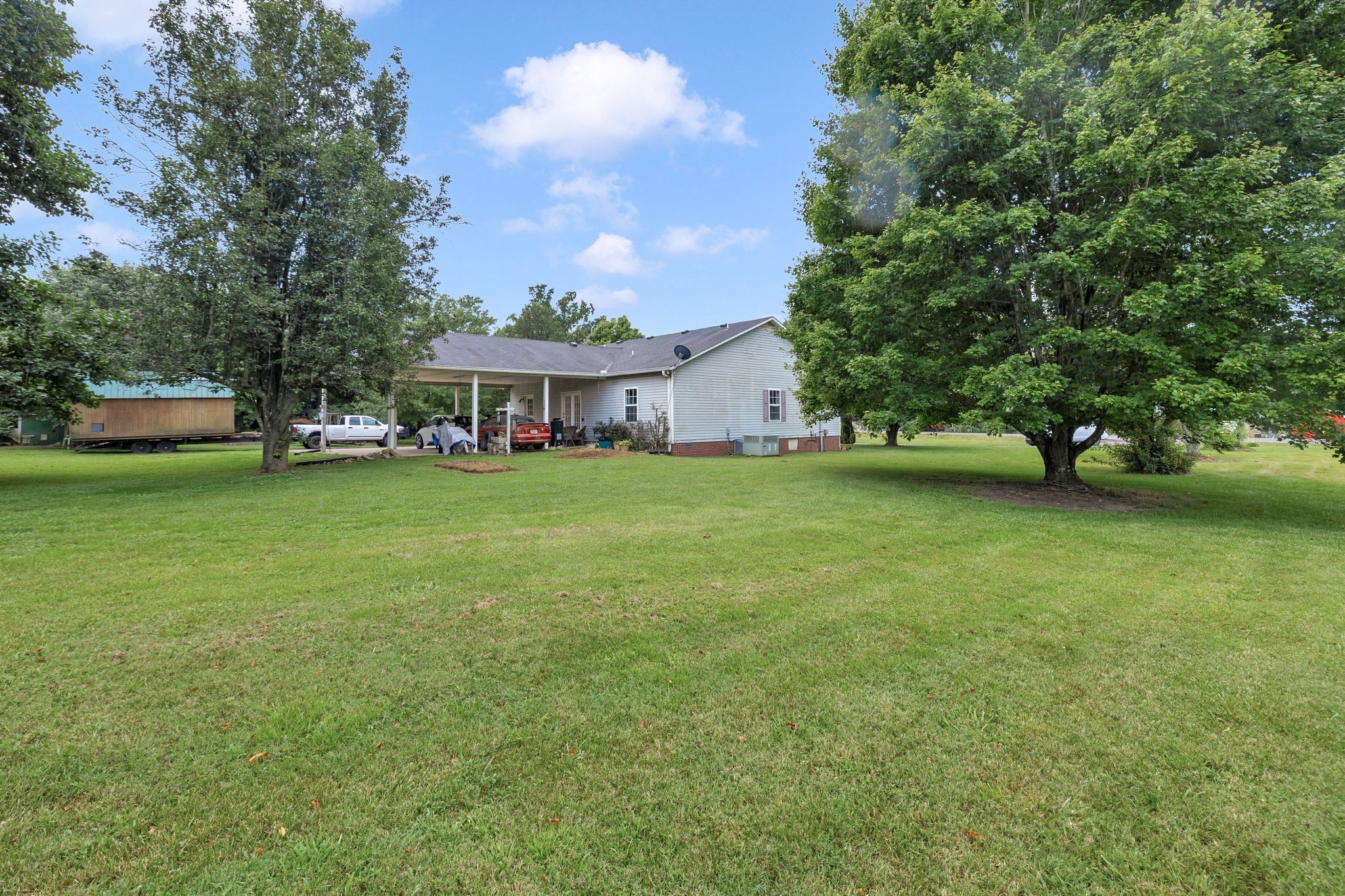 876 Monument Road Summertown, TN 38483 - Photo 24 of 26 a view of a house with a big yard and large trees