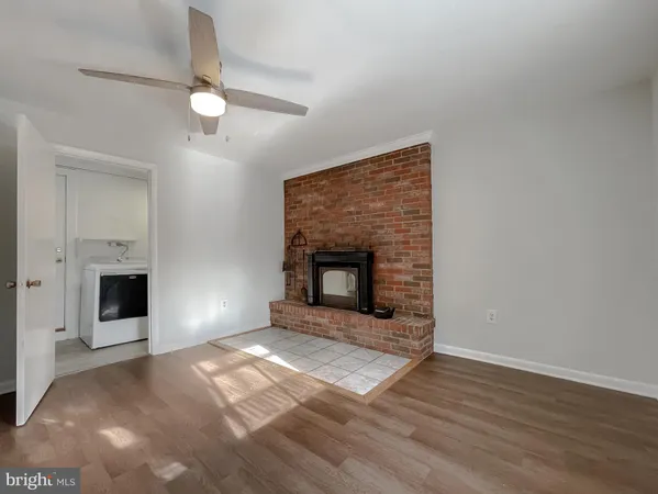 a view of an empty room with a fireplace and a window