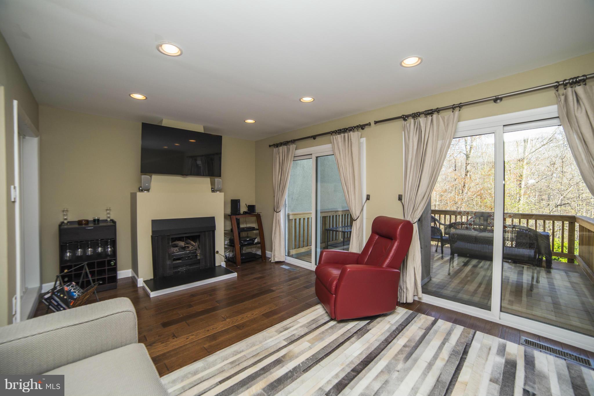 1613 Valencia Way Reston, VA 20190 - Photo 4 of 29 a living room with furniture a flat screen tv and a fireplace