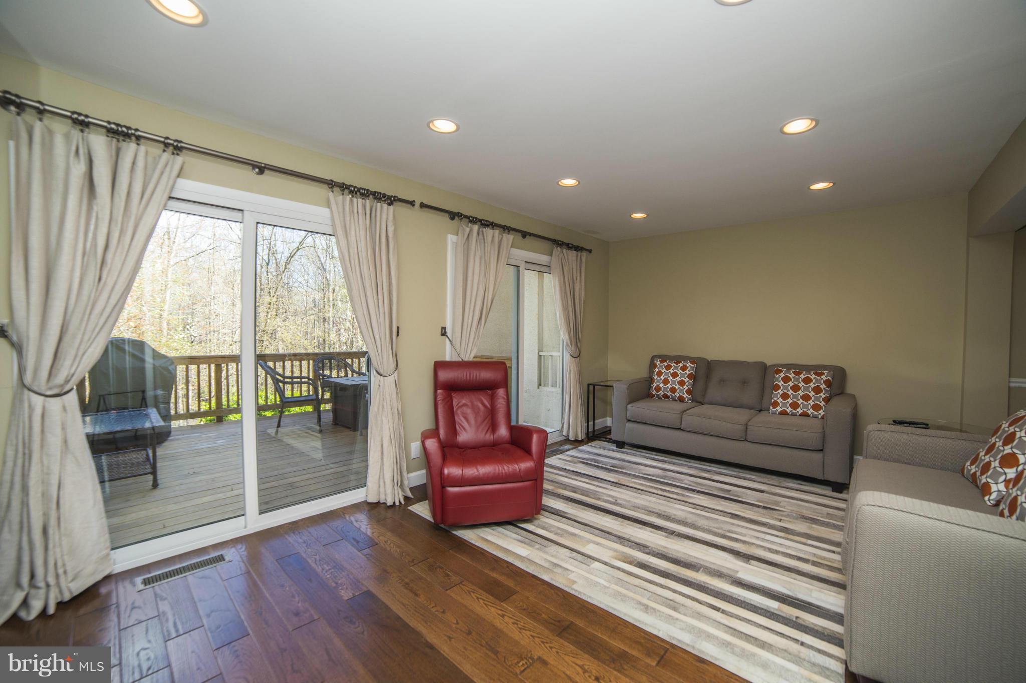 1613 Valencia Way Reston, VA 20190 - Photo 6 of 29 a spacious bedroom with a bed a table and glass door