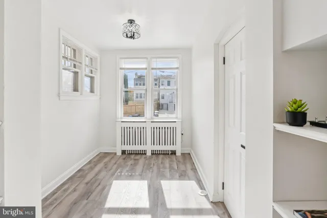 a view of a hallway with wooden floor and windows
