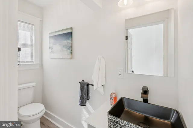 a bathroom with a sink a toilet and a mirror