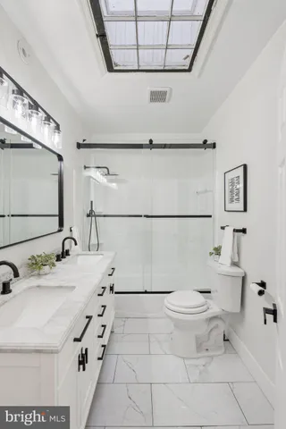 a bathroom with a sink a toilet and a mirror