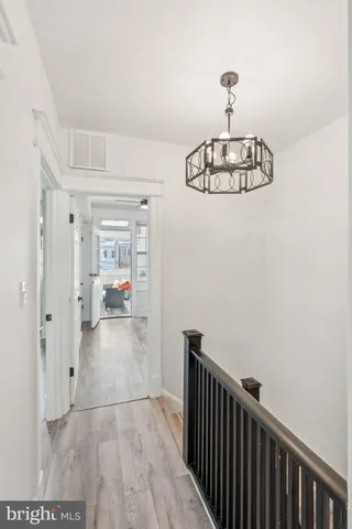 a view of a hallway with wooden floor and dining room