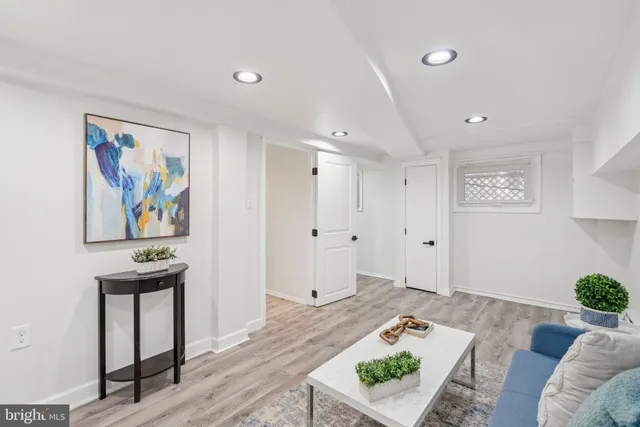 a living room with furniture and a painting on the wall