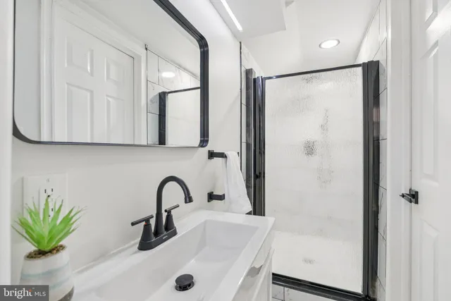 a bathroom with a sink a mirror and a shower