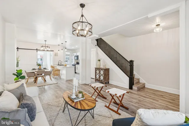 a living room with furniture a dining table and a chandelier