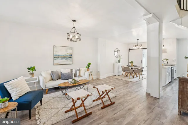 a living room with furniture a dining table and paintings on the wall