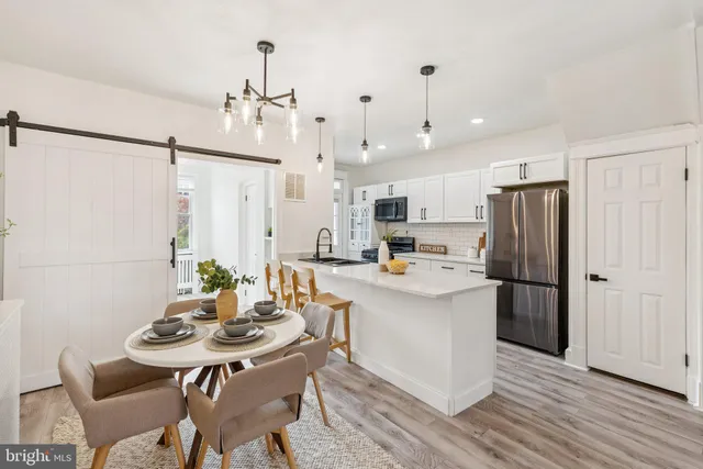 a kitchen with a sink a refrigerator and wooden floor