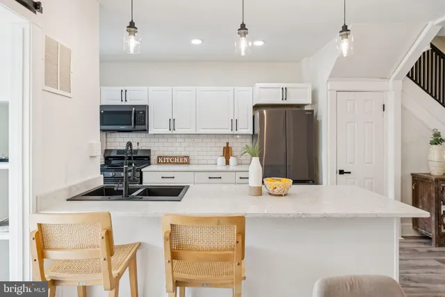 a kitchen with stainless steel appliances a stove a sink and a refrigerator