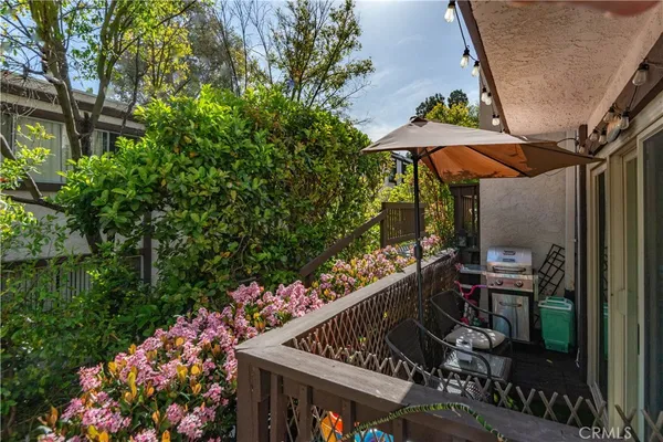 a patio with table and chairs and potted plants