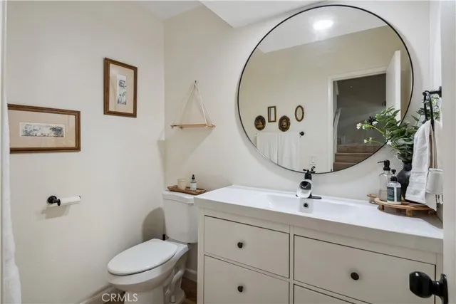 a bathroom with a toilet a sink and mirror