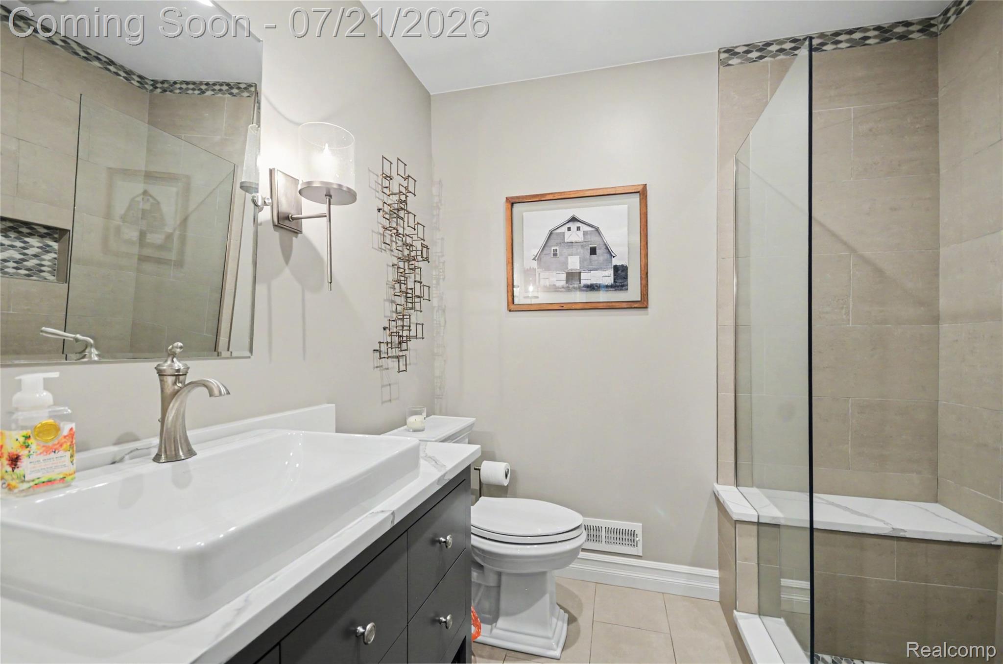 3780 Squirrel Road Bloomfield Hills, MI 48304 - Photo 17 of 59 Contemporary bathroom featuring a dark wood-finish vanity with a vessel sink, a walk-in shower with a glass enclosure, an integrated shower bench, and neutral-toned wall and floor tiling