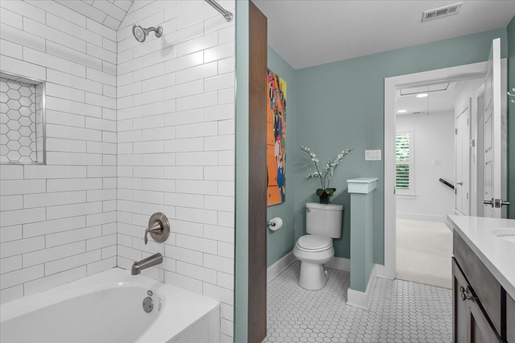 12200 Tawny Farms Road, Unit 139 Austin, TX 78748 - Photo 19 of 30 On the other side of the primary bath, you have a gorgeous shower-tub combo lined with classic white subway tile and a matching hex-tile accent niche.