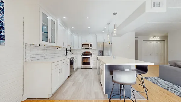 a large kitchen with stainless steel appliances kitchen island granite countertop a sink and cabinets