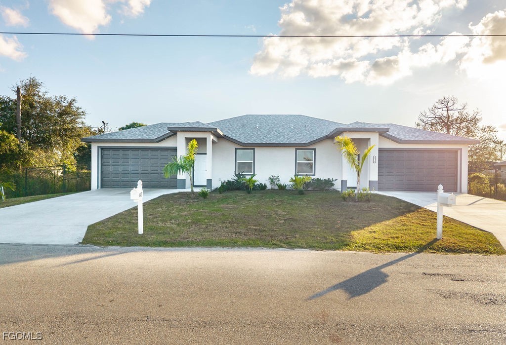 4417 22nd Street Southwest Lehigh Acres, FL 33973 - Photo 1 of 36 a front view of a house with a garden and garage
