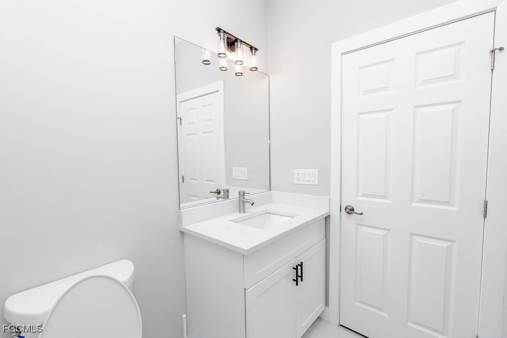 4417 22nd Street Southwest Lehigh Acres, FL 33973 - Photo 29 of 36 a bathroom with a sink a toilet and a mirror