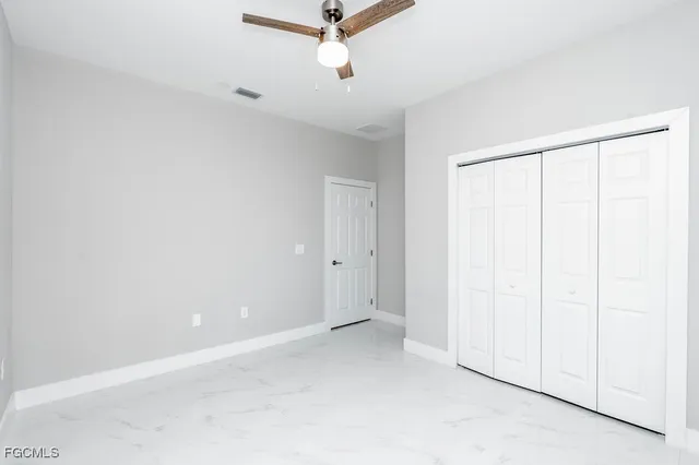 an empty room with a ceiling fan and a window