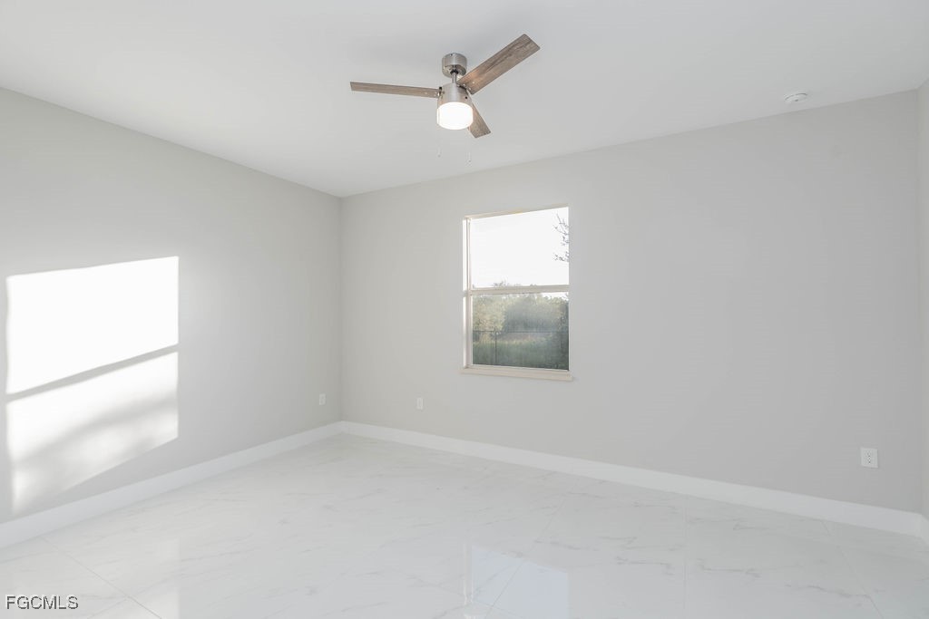 4417 22nd Street Southwest Lehigh Acres, FL 33973 - Photo 35 of 36 an empty room with a window and a ceiling fan