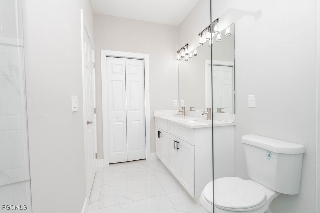 4417 22nd Street Southwest Lehigh Acres, FL 33973 - Photo 36 of 36 a bathroom with a double vanity sink toilet and shower