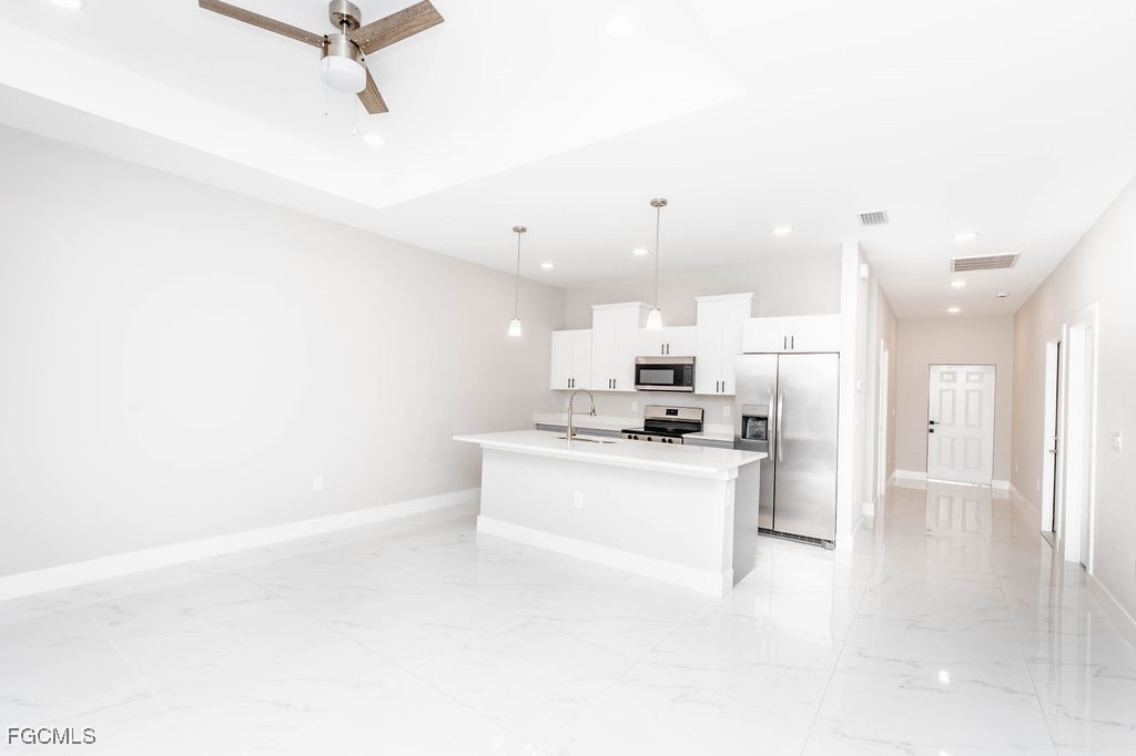 4417 22nd Street Southwest Lehigh Acres, FL 33973 - Photo 4 of 36 a view of a kitchen with kitchen island a sink a stove and a refrigerator