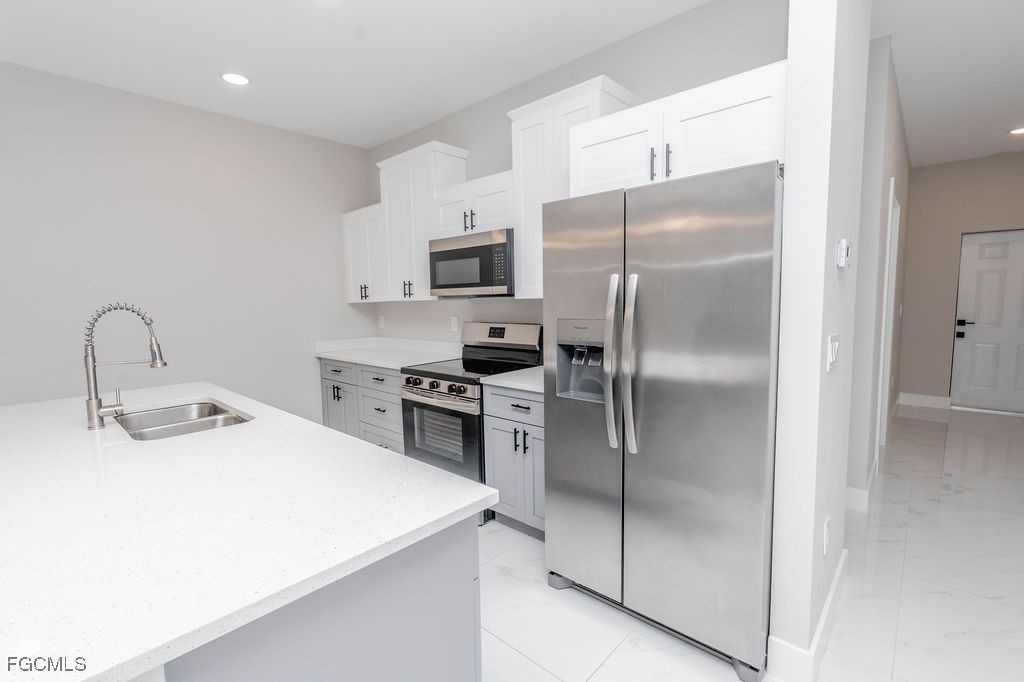 4417 22nd Street Southwest Lehigh Acres, FL 33973 - Photo 5 of 36 a kitchen with stainless steel appliances a refrigerator sink and microwave