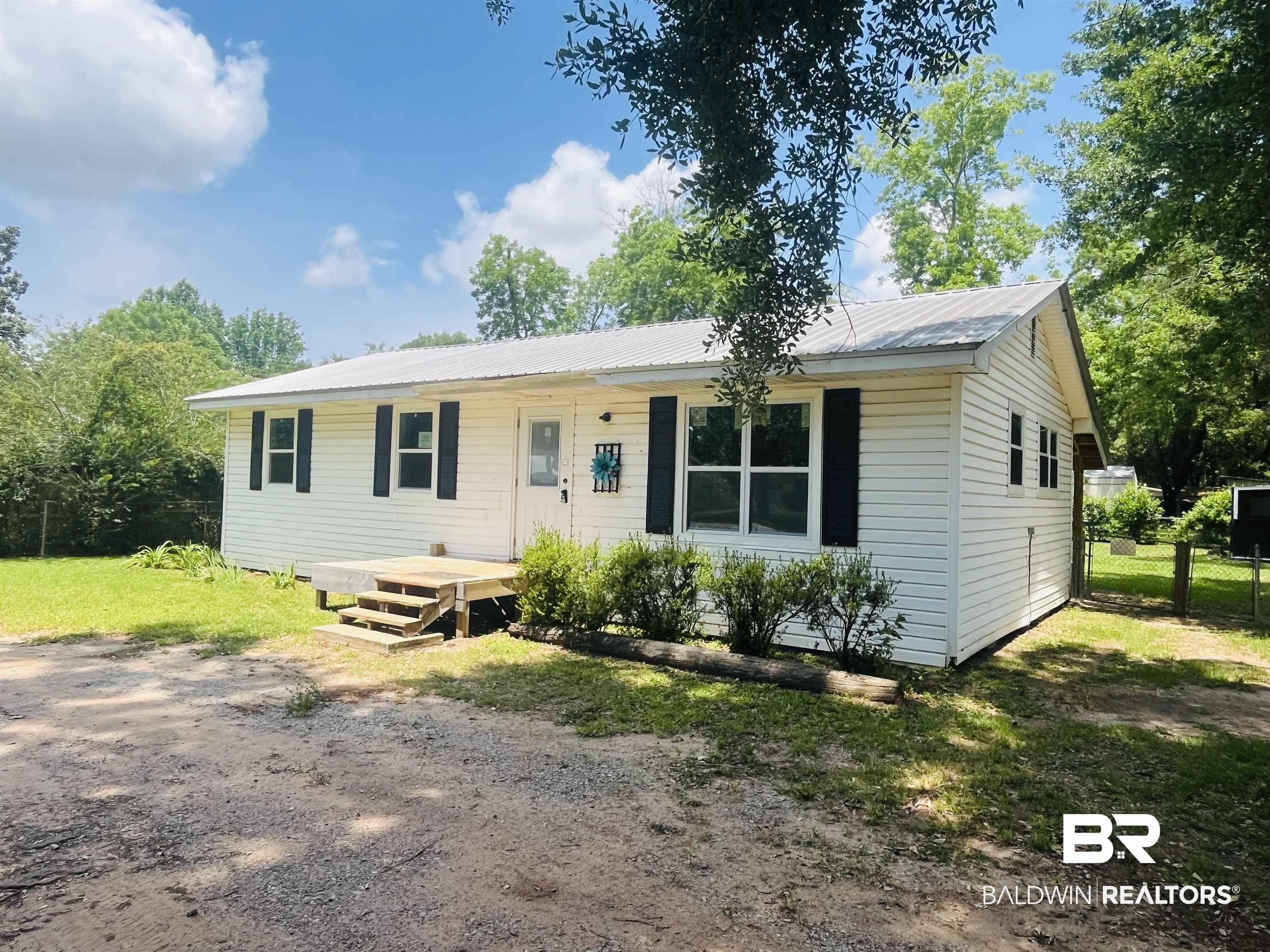 18855 Crocker Lane Foley, AL 36535 - Photo 2 of 25 Ranch-style home with metal roof, fence, and covered porch