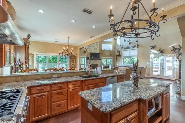 a kitchen with granite countertop a sink a counter space appliances and cabinets