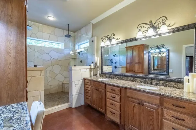 a bathroom with a double vanity sink mirror and shower