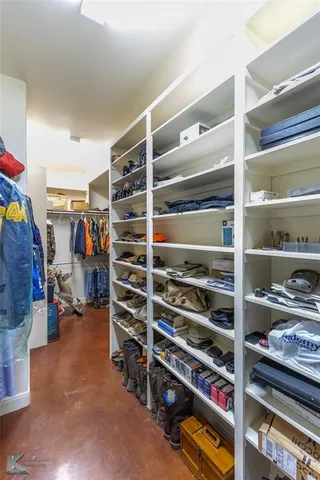 a view of walk in closet with clothes and shoes