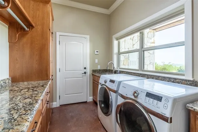 a view of washer and dryer with bathroom in the background