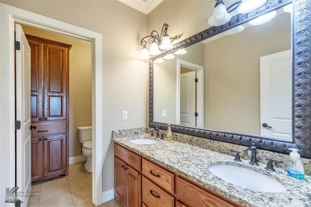 a bathroom with a granite countertop sink a light fixture and a mirror