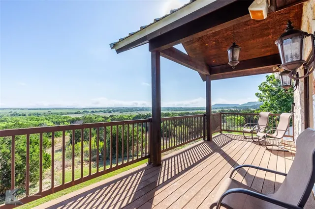 a view of a balcony with chairs and wooden floor