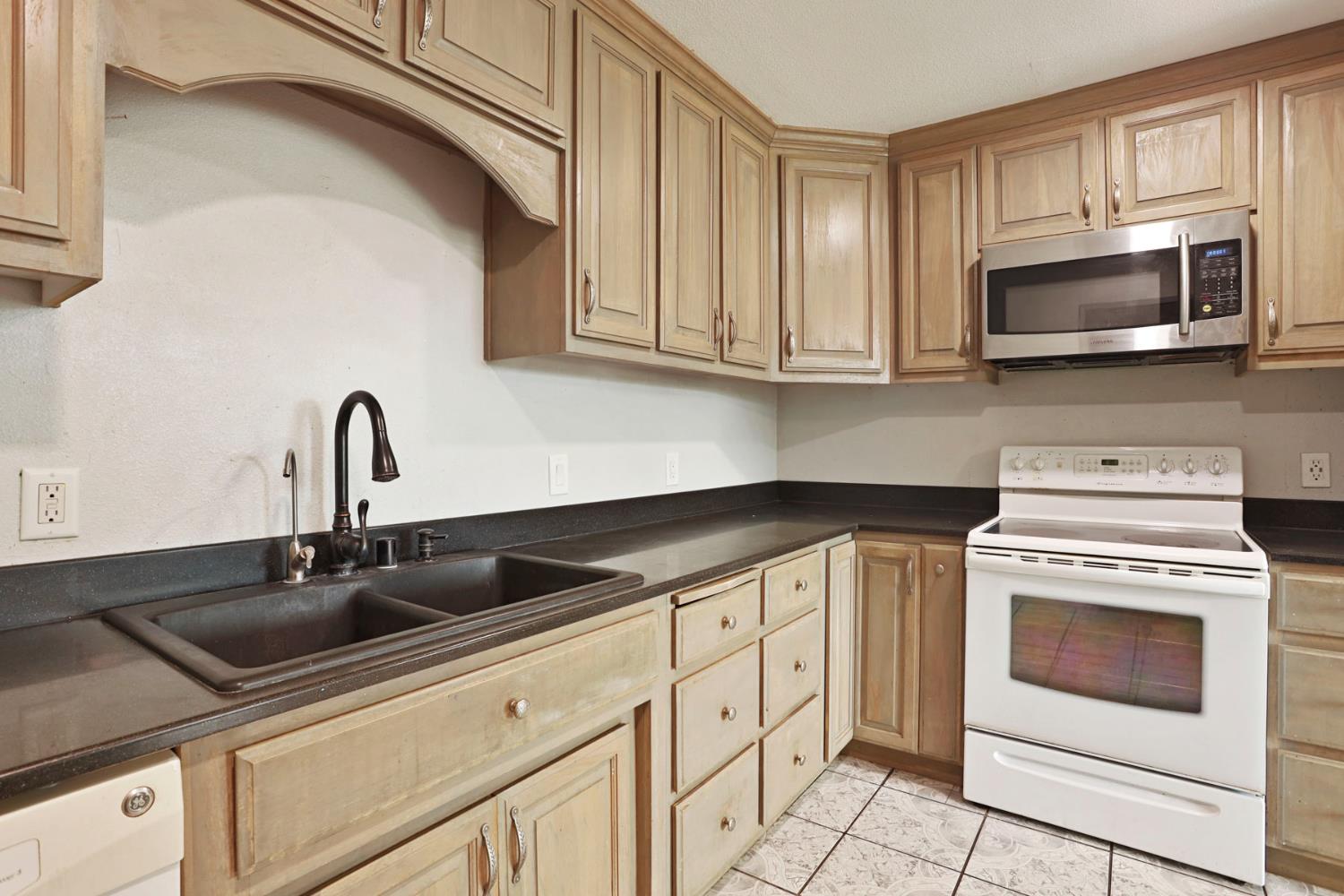2443 Fern Street Merced, CA 95348 - Photo 13 of 50 a kitchen with white cabinets and stainless steel appliances
