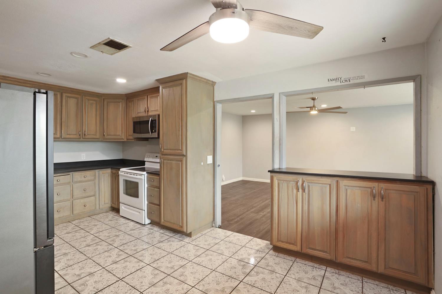2443 Fern Street Merced, CA 95348 - Photo 15 of 50 a kitchen with granite countertop white cabinets and stainless steel appliances