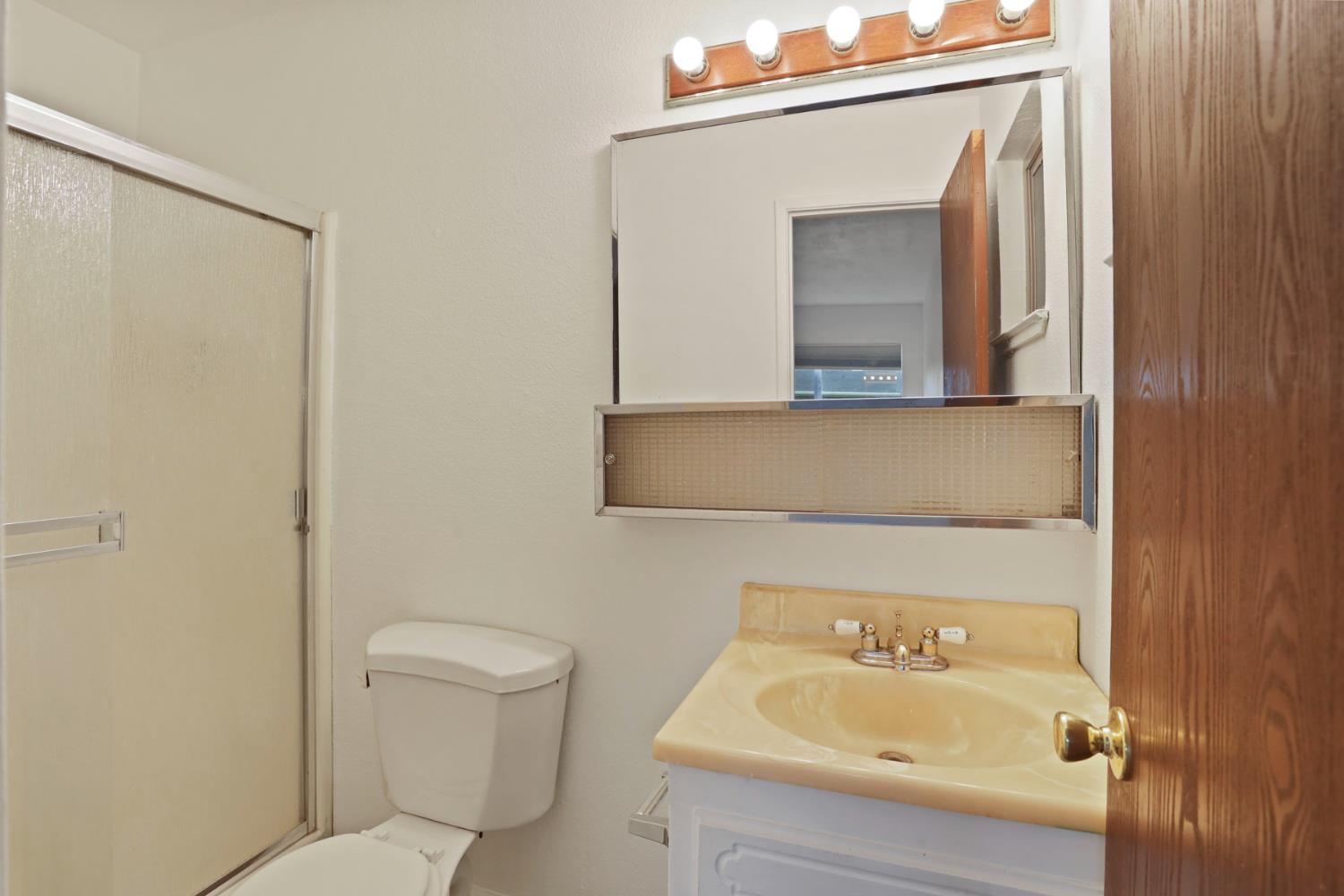 2443 Fern Street Merced, CA 95348 - Photo 25 of 50 a bathroom with a sink a toilet and mirror
