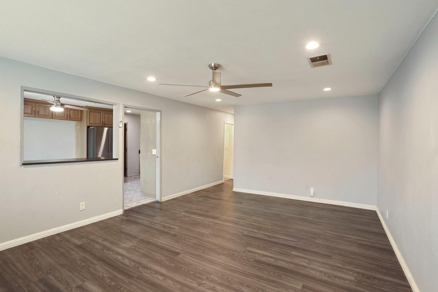 2443 Fern Street Merced, CA 95348 - Photo 7 of 50 a view of an empty room with wooden floor and a ceiling fan