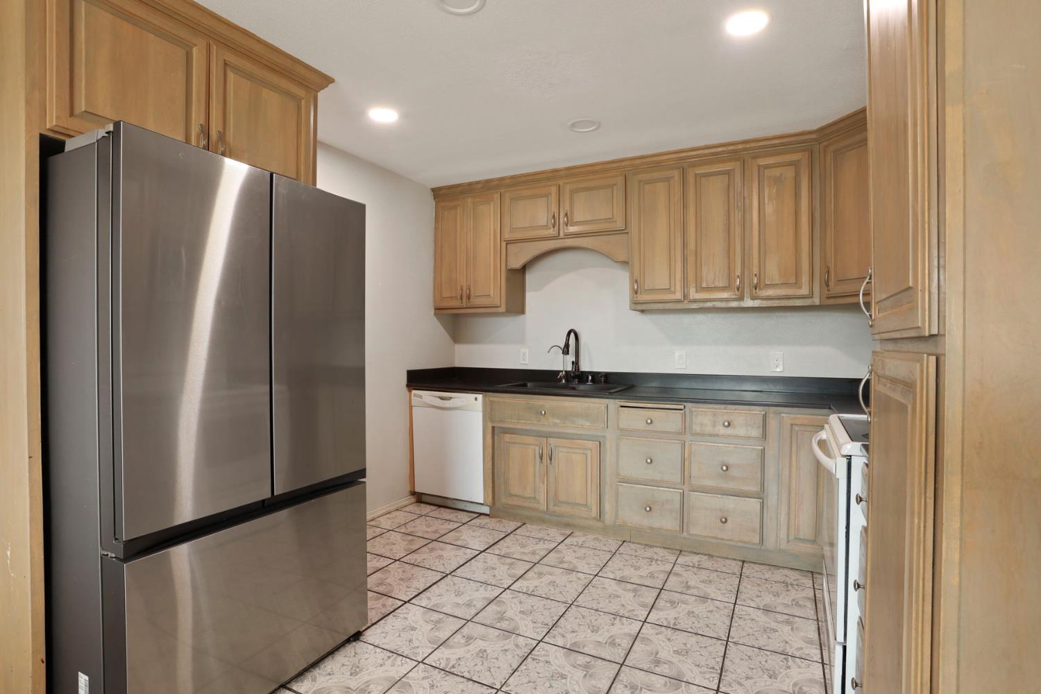 2443 Fern Street Merced, CA 95348 - Photo 10 of 50 a kitchen with stainless steel appliances granite countertop a refrigerator and a sink