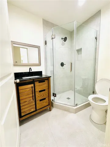 a bathroom with a shower sink vanity and toilet