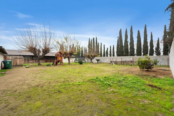 a view of a house with backyard and a tree