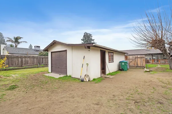a view of a backyard with plants and wooden fence