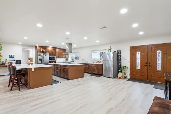 a kitchen with stainless steel appliances a table chairs and a refrigerator