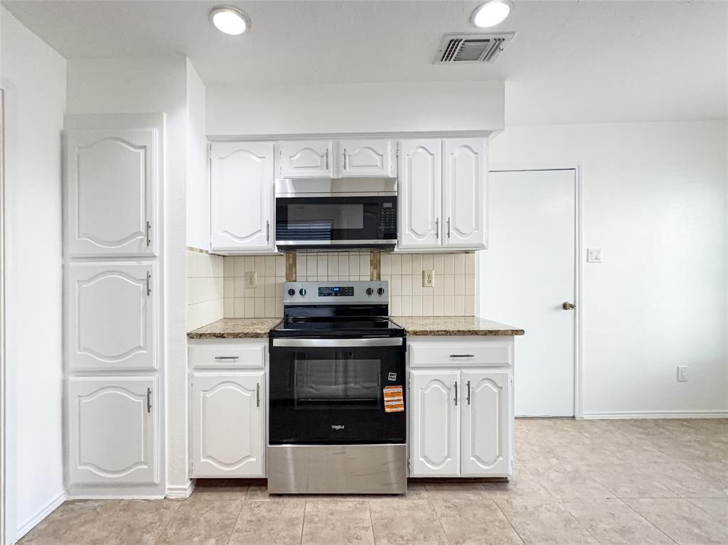 17490 Meandering Way, Unit 1102 Dallas, TX 75252 - Photo 10 of 40 a kitchen with stainless steel appliances granite countertop a stove and a refrigerator