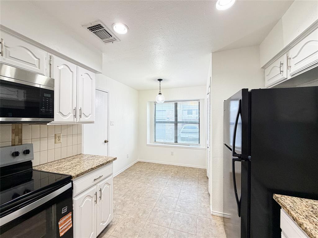 17490 Meandering Way, Unit 1102 Dallas, TX 75252 - Photo 15 of 40 a kitchen with stainless steel appliances a refrigerator sink and stove