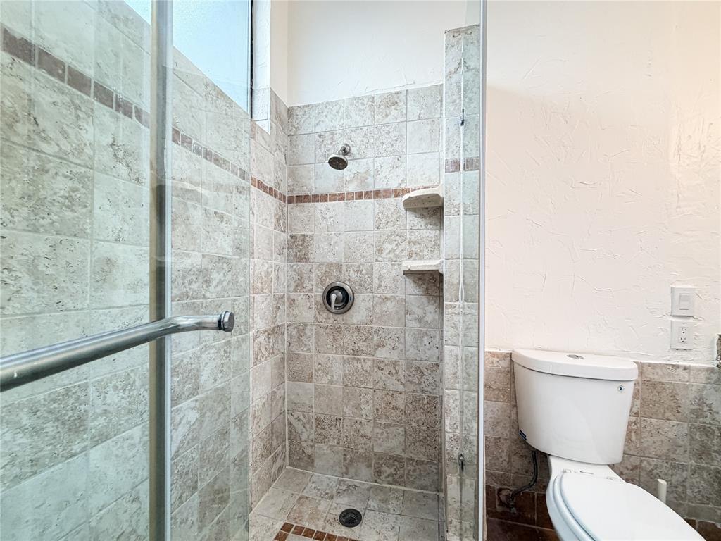17490 Meandering Way, Unit 1102 Dallas, TX 75252 - Photo 20 of 40 a white toilet sitting next to a bathroom shower