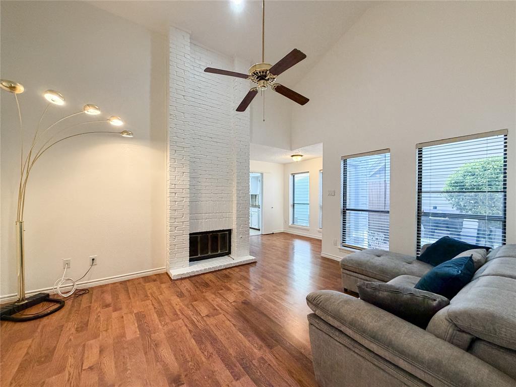 17490 Meandering Way, Unit 1102 Dallas, TX 75252 - Photo 5 of 40 Living area featuring vaulted ceiling, laminate floors, a ceiling fan, and a fireplace