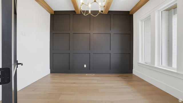 1682 North 1950 W Street, Unit 9 Provo, UT 84604 - Photo 12 of 84 Room featuring wood-finish flooring, a paneled accent wall, exposed ceiling beams, and a brass chandelier