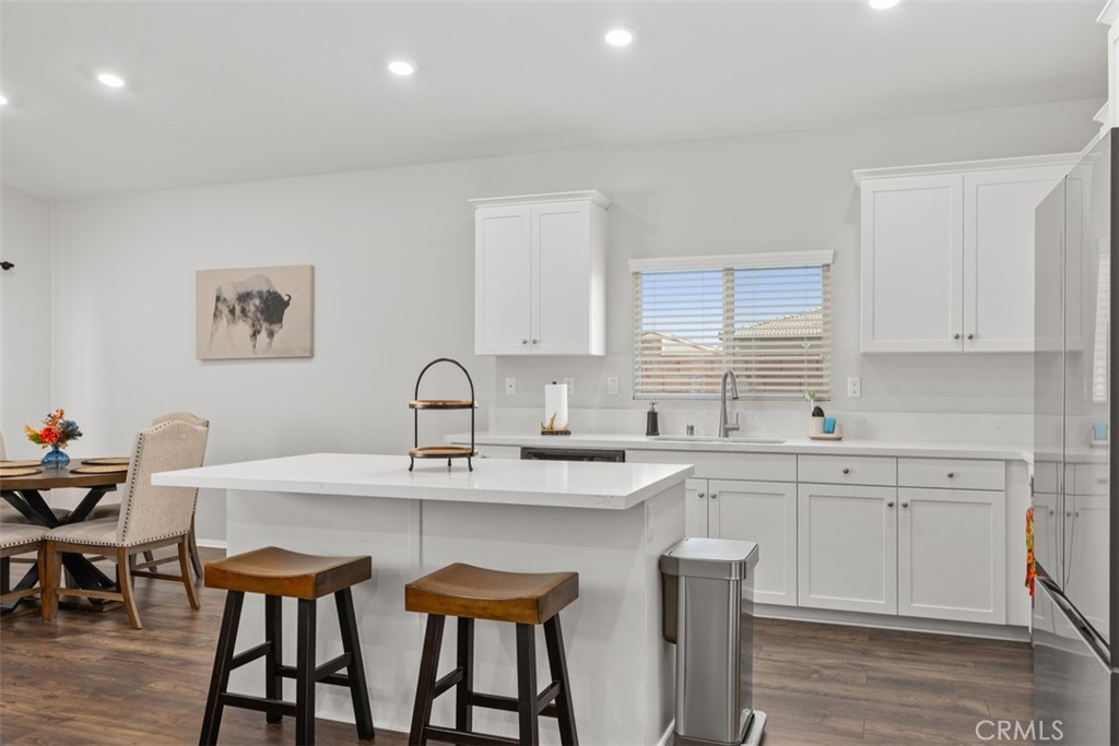 28471 Cosmos Drive Winchester, CA 92596 - Photo 17 of 27 a kitchen with a dining table chairs and white cabinets