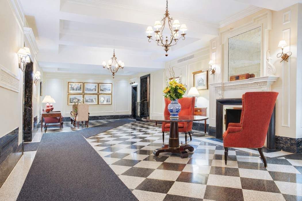 47 East 88th Street, Unit 8A Manhattan, NY 10128 - Photo 23 of 27 a living room with furniture a fireplace a rug and a window